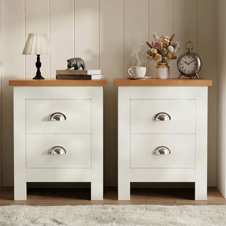 [White] Pair of white bedside table pair on rug, oak tops, cup handles, lamp and books left, vase and frame right