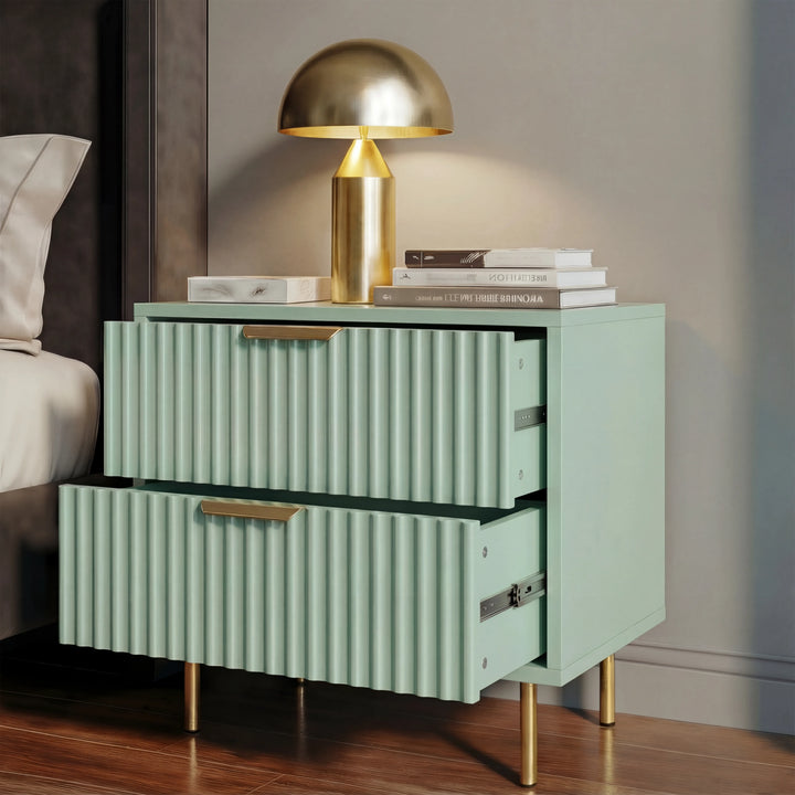 [Sage Green] nightstand with gold legs and handles beside a bed, displaying two drawers partially open in soft natural lighting