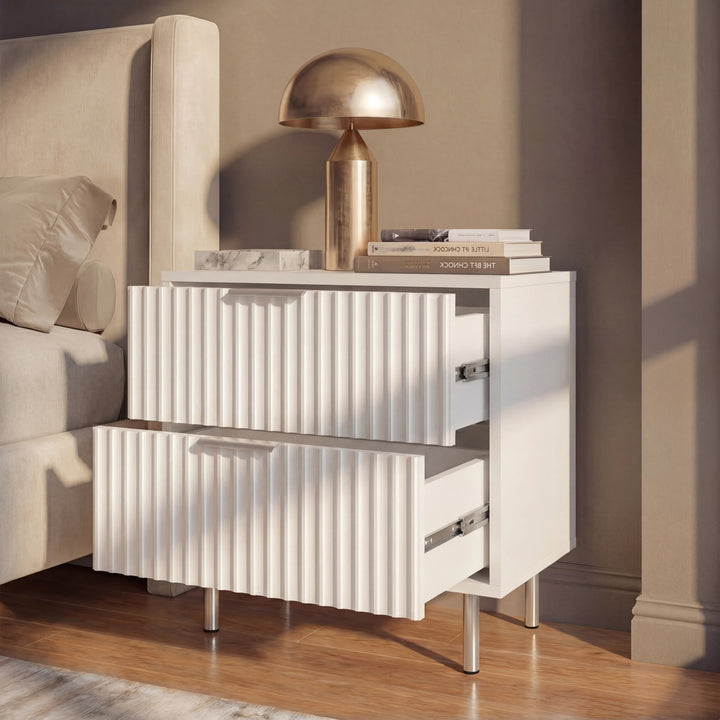 [White] Bedside table beside a bed, shown with two drawers partially open in soft natural lighting