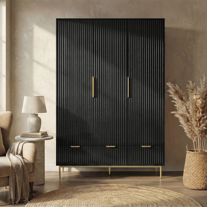 [Black] flutrina design triple wardrobe with three drawers and golden legs placed against a wall in a natural light room