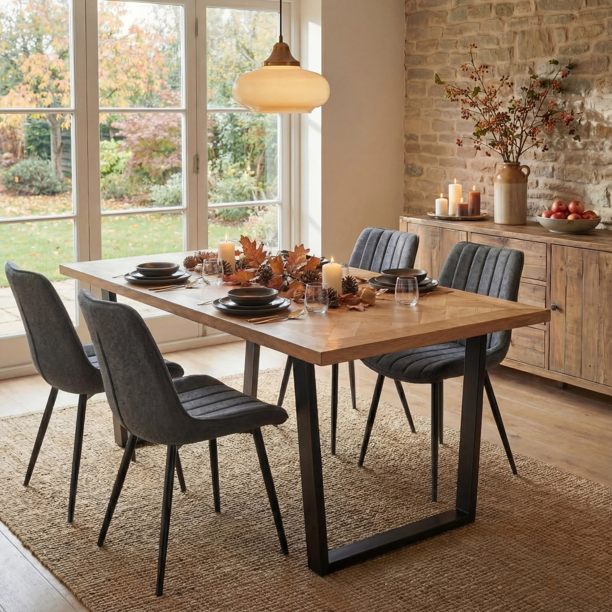 [4 Seater | Grey] Aldridge dining table with 4 grey chairs styled with autumn leaves, pumpkin candles and amber glassware.