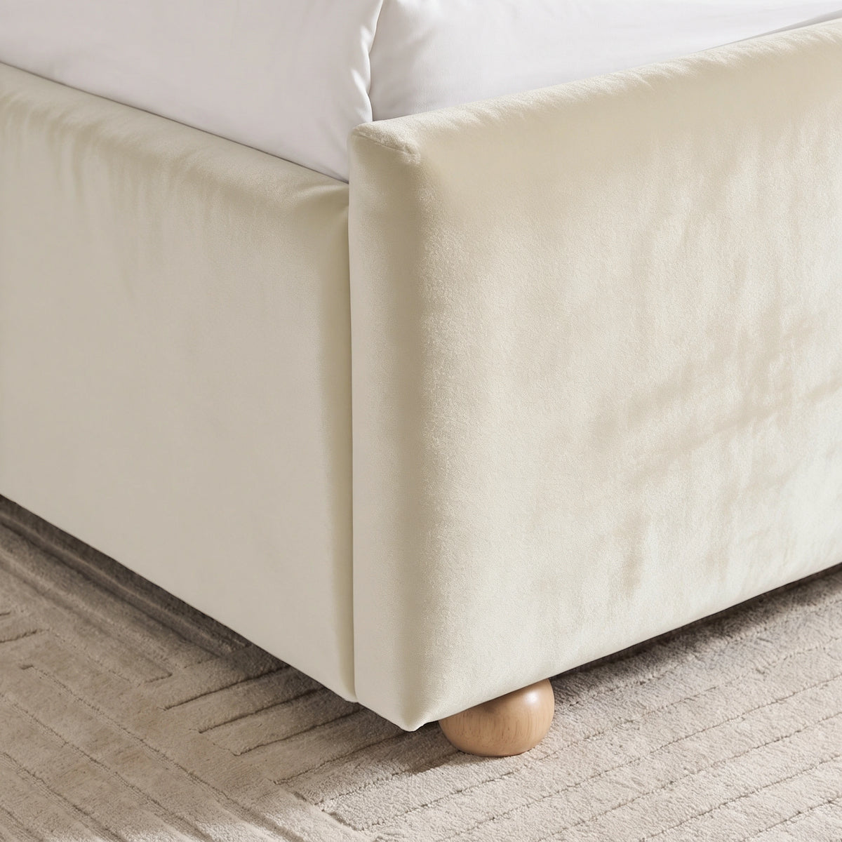[Beige | Double] Close-up of beige plush velvet footboard corner, raised side rail and low round wooden foot