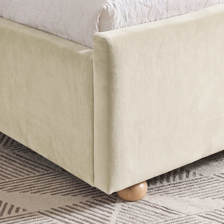 [Beige | King] Close-up of beige plush velvet footboard corner, raised side rail and low round wooden foot