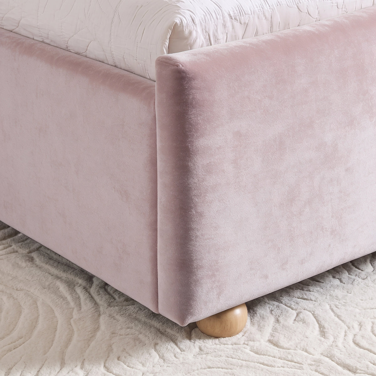 [Pink | King] Close-up of pink plush velvet footboard corner, raised side rail and low round wooden foot