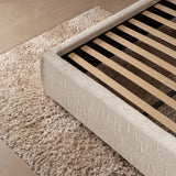 [Double | Beige] Embracea bed frame close-up showing solid wooden slat support system and upholstered curved side rail