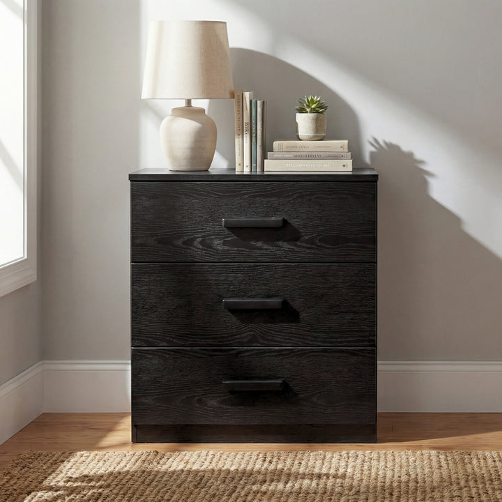 [Black] three drawer bedroom chest placed in styled room setting, freestanding storage with flat front panels