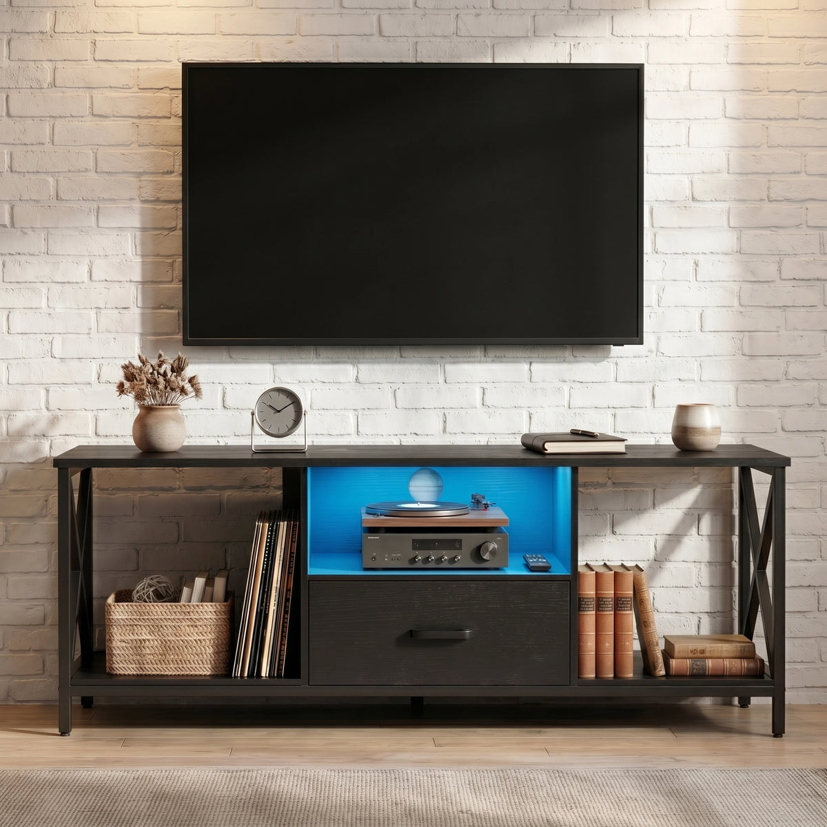 [Black] Calvera TV unit front-on view with blue LED-lit shelf, open storage and X-frame sides against brick wall