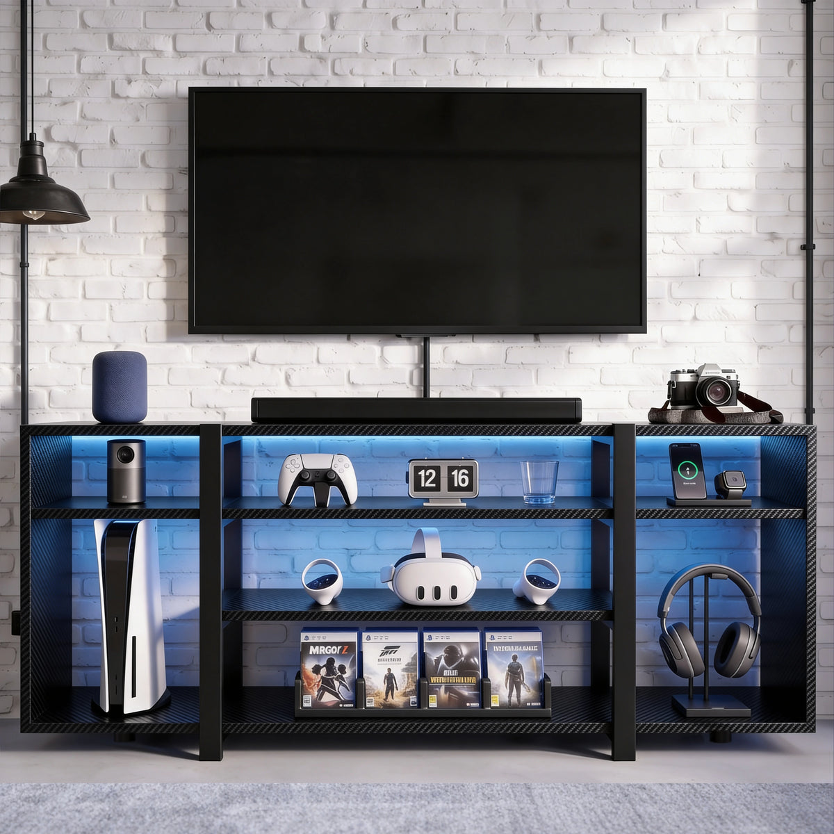[Black Carbon Fibre] Zelumi TV stand in a brick-wall room with blue LED shelves holding consoles, VR headset, game cases, and headphones on stand