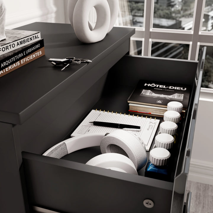 [Black] close-up of open top drawer of black high gloss chest with headphones, books and accessories inside