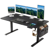 [160cm x 70cm] Electric Standing Desk Height Adjustable showing an expansive four-screen multi-monitor workstation arrangement on a wide black desktop with a hanging headset and side storage pocket.