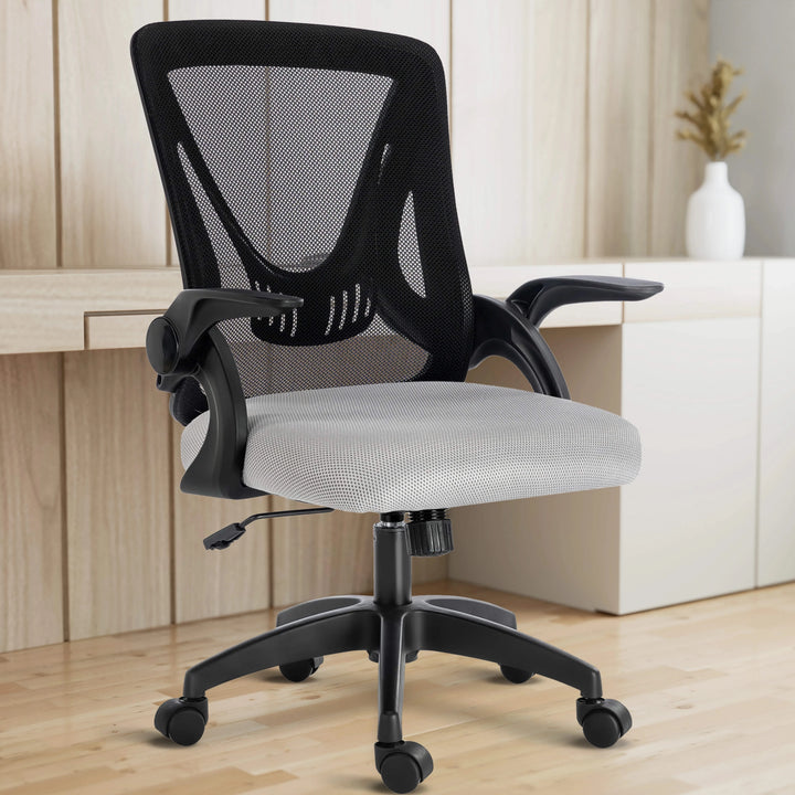 [Black + Grey] The black and grey mesh chair sits comfortably in a home office, with a working desk in the backdrop.