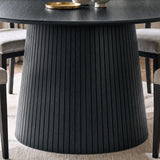 [Black] Close-up of round pedestal dining table slatted pedestal base below the table top showing slats