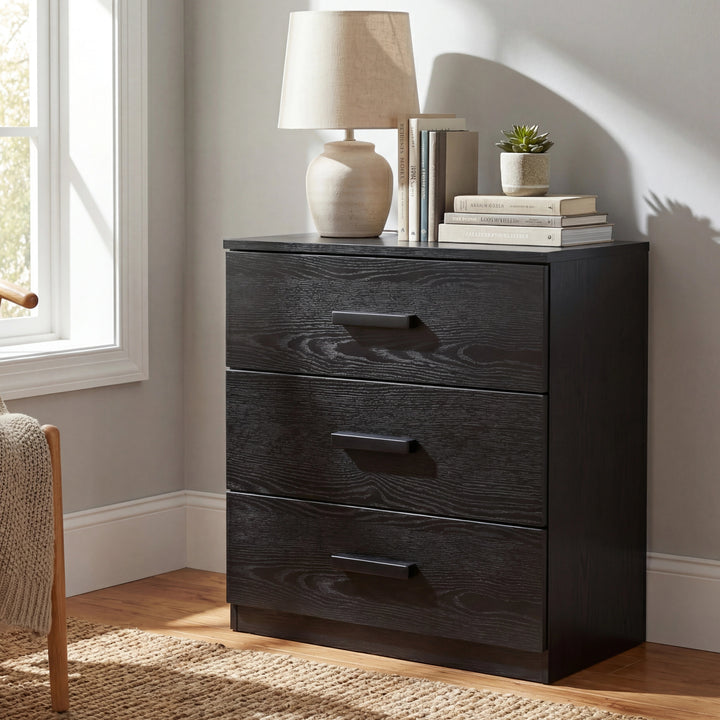 [Black] plain 3 drawer chest shown front facing against neutral wall, compact bedroom storage unit