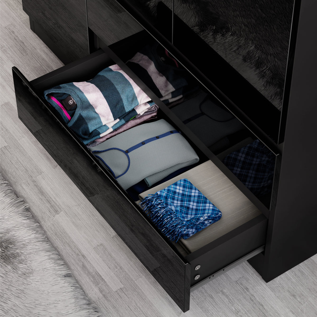 [Black] Open drawer detail of 3 door wardrobe revealing smooth-glide runner and folded garments inside.