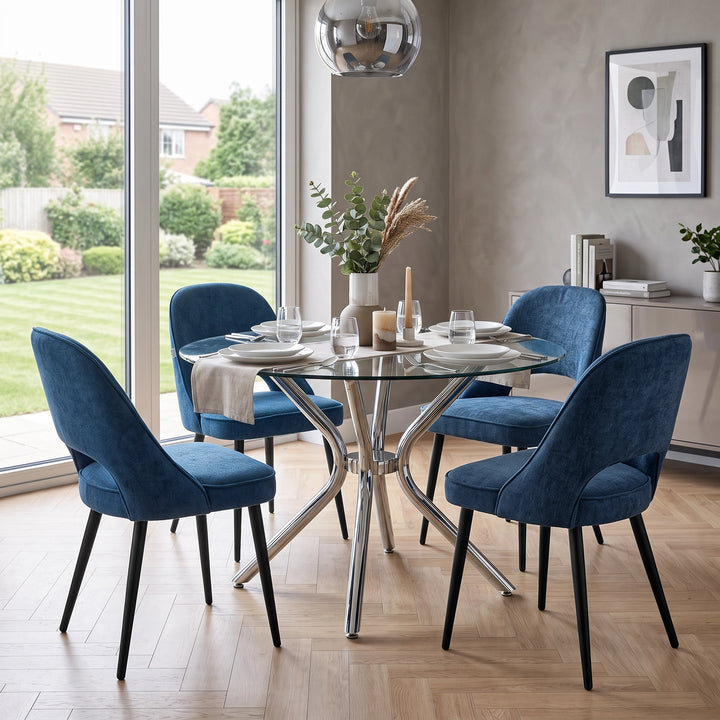 [Blue | Set of 2] Two pairs of the comfy dining chairs around a round glass table with chrome base, tableware, & a vase
