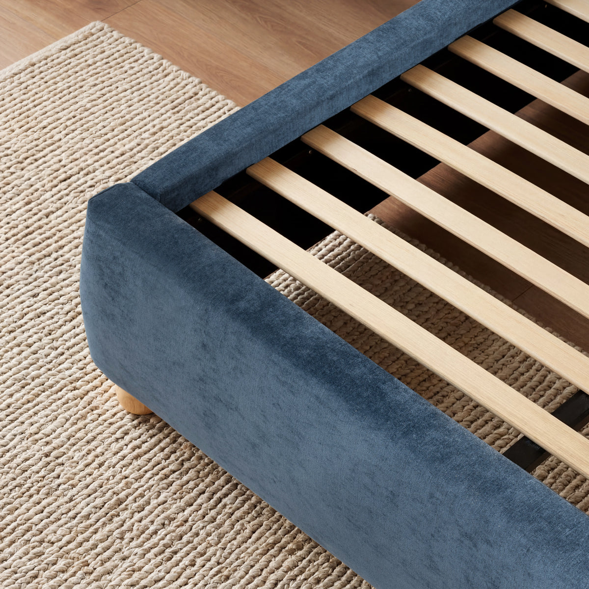 [King | Blue] A close view of wooden slat support system for the mattress, in the upholstered blue king frame