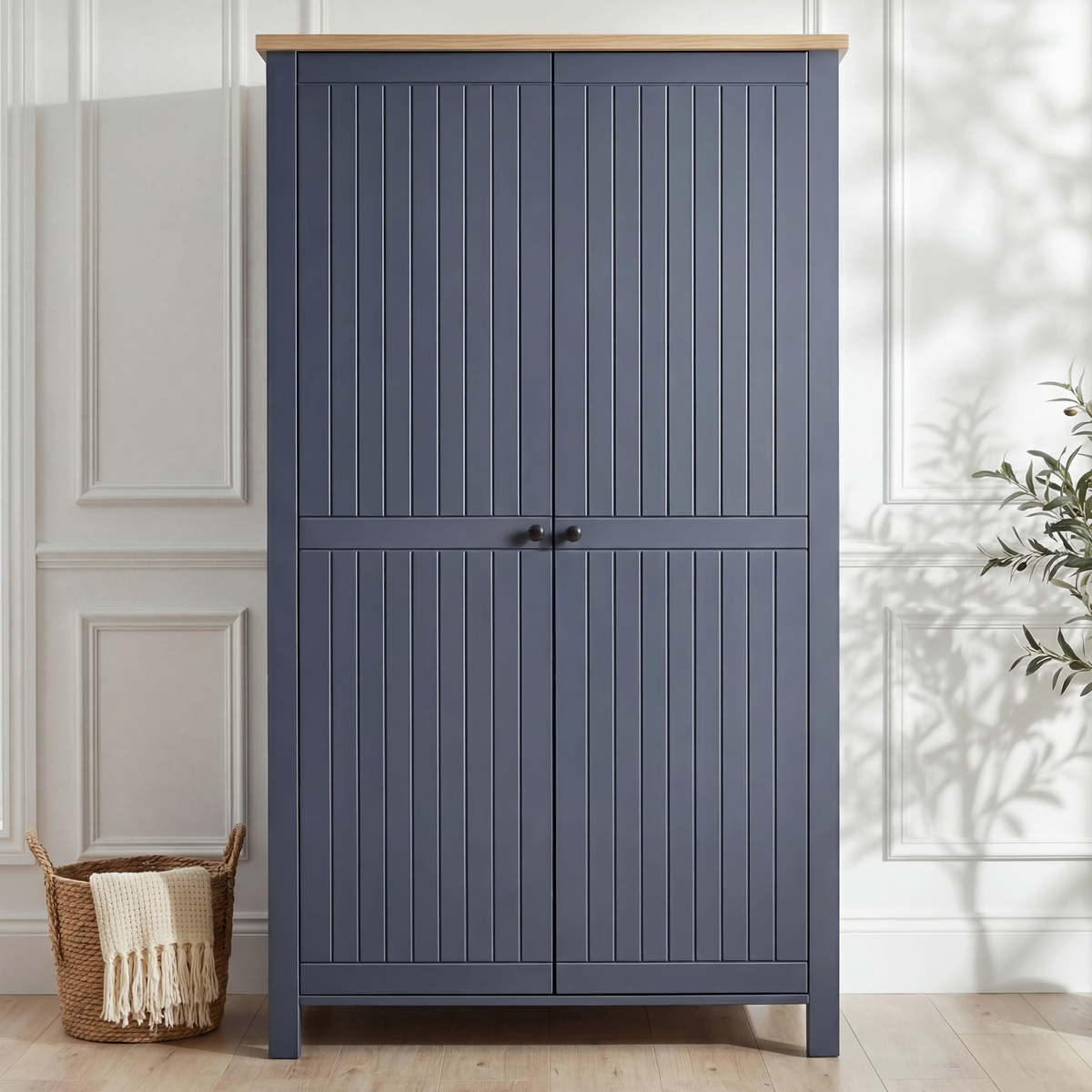 [Blue] Linra 2 Door Wardrobe front view in a bright white panelled room with wicker basket to the left and olive tree to the right