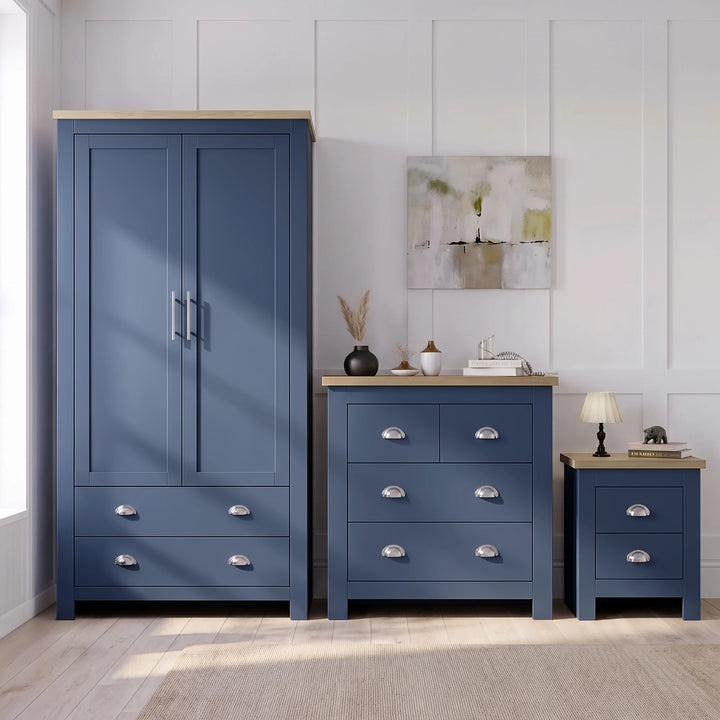 [Blue] Wardrobe, chest and bedside shown together against panelled wall with oak tops, decor, lamp, and rug