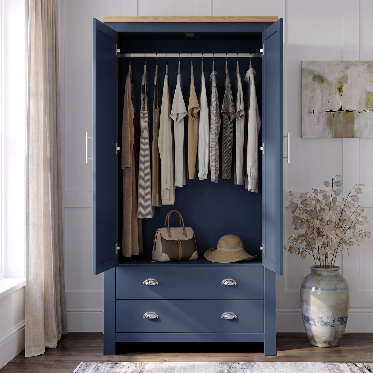 [Blue] wardrobe with a light wood top, shown open in a styled room. Inside, multiple garments hang on a rod, and a handbag and hat rest on a shelf.
