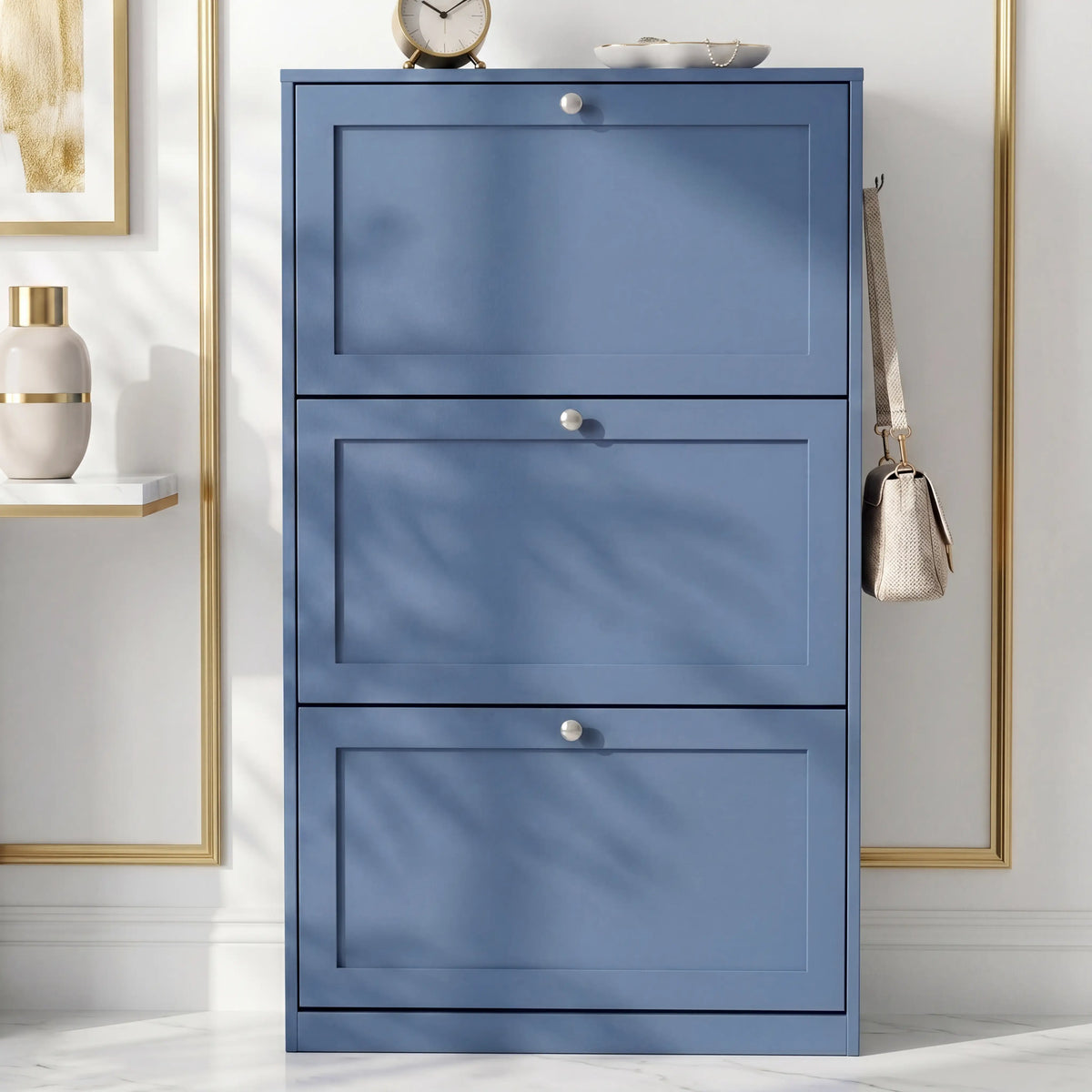 [Blue] Shaker Shoe Cabinet closed three-door flip-front unit against white panelled wall with woven basket and linen tote bag alongside