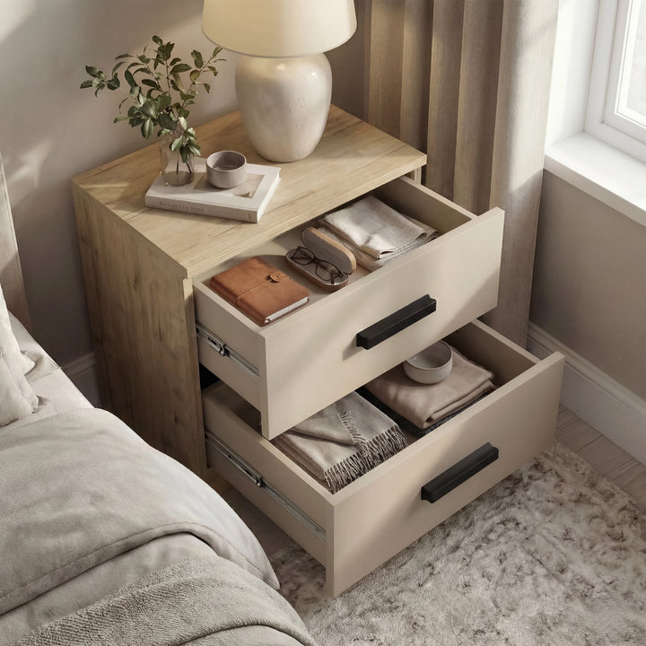 [Oak Cashmere] Bedside of the Blythe bedroom furniture set open beside a bed with oak top and cashmere fronts