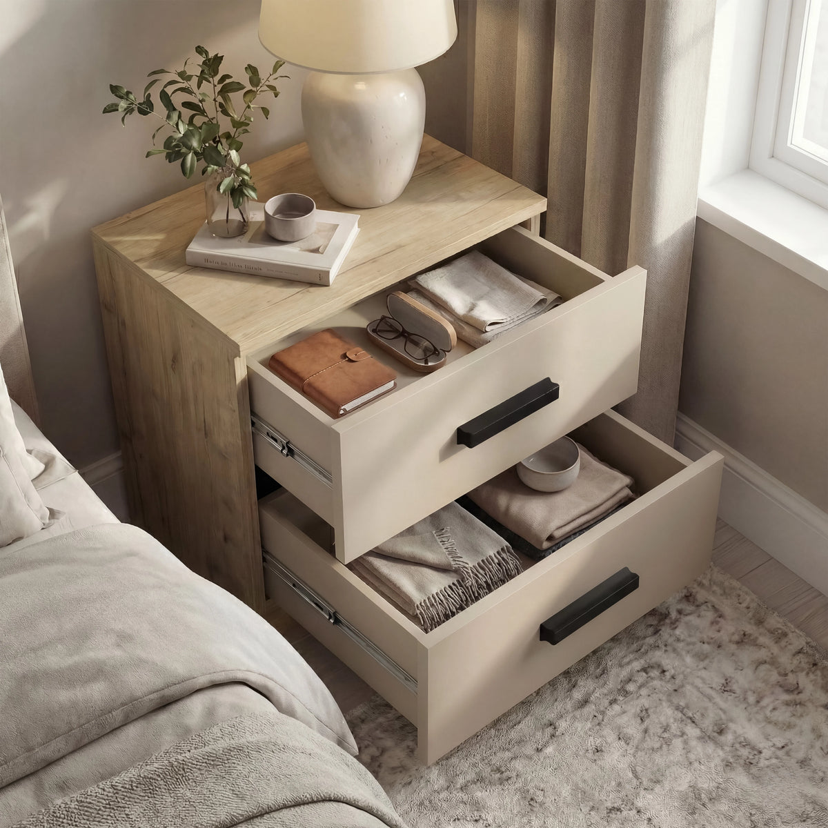 [Oak Cashmere] Open drawers of oak bedside table revealing folded items, lamp and dish remain on the oak top