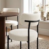 [Cream | Set of 4] lifestyle view of boucle dining chair with curved backrest and black metal frame.