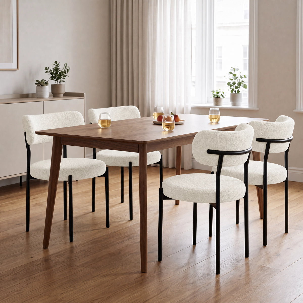 [Cream | Set of 4] Four boucle dining chairs around a rectangular wooden dining table in a bright room.