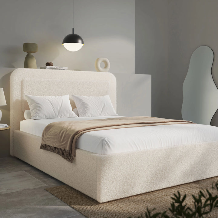 Wide angle of beige boucle king ottoman bed, gas-lift base with folded striped throw across foot