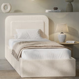 [Single | Beige] Beige boucle single ottoman bed angled view, rounded pill headboard beside fluted lamp and pebble vase shelf