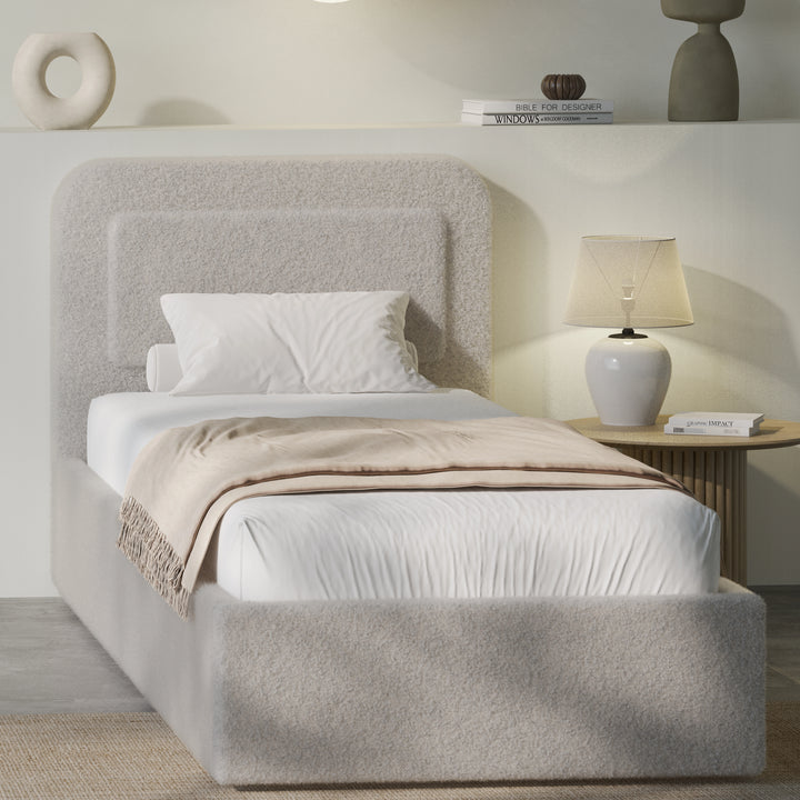 [Single | Grey] Grey boucle single ottoman bed angled, soft greige pill headboard and gas-lift base with beige throw