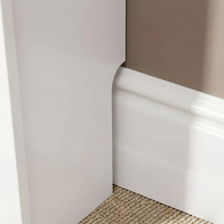 [Small] Chelsea White Radiator Cover base leg close-up showing recessed skirting board cutout allowing flush fit against a profiled wall skirting