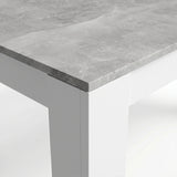 [Concrete] Close-up of the grey concrete-effect tabletop corner; the mottled top meets a thick white square L-shaped leg.