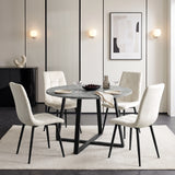 [Concrete] Round dining table set for four with plates and glasses, surrounded by white chairs on a neutral rug.