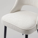 [Cream | Set of 2] Comfy dining chair close-up view of woven seat, piped edge, curved open back and black metal legs