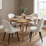 [Cream | Set of 4] Four curved-back dining chairs at a wood table set for four styled with tableware and a vase.