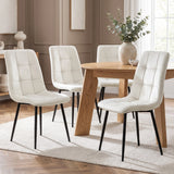 [Cream | Set of 4] Velvet dining chairs around a rectangular wood-effect table, showing curved tufted backs and slim black metal legs.