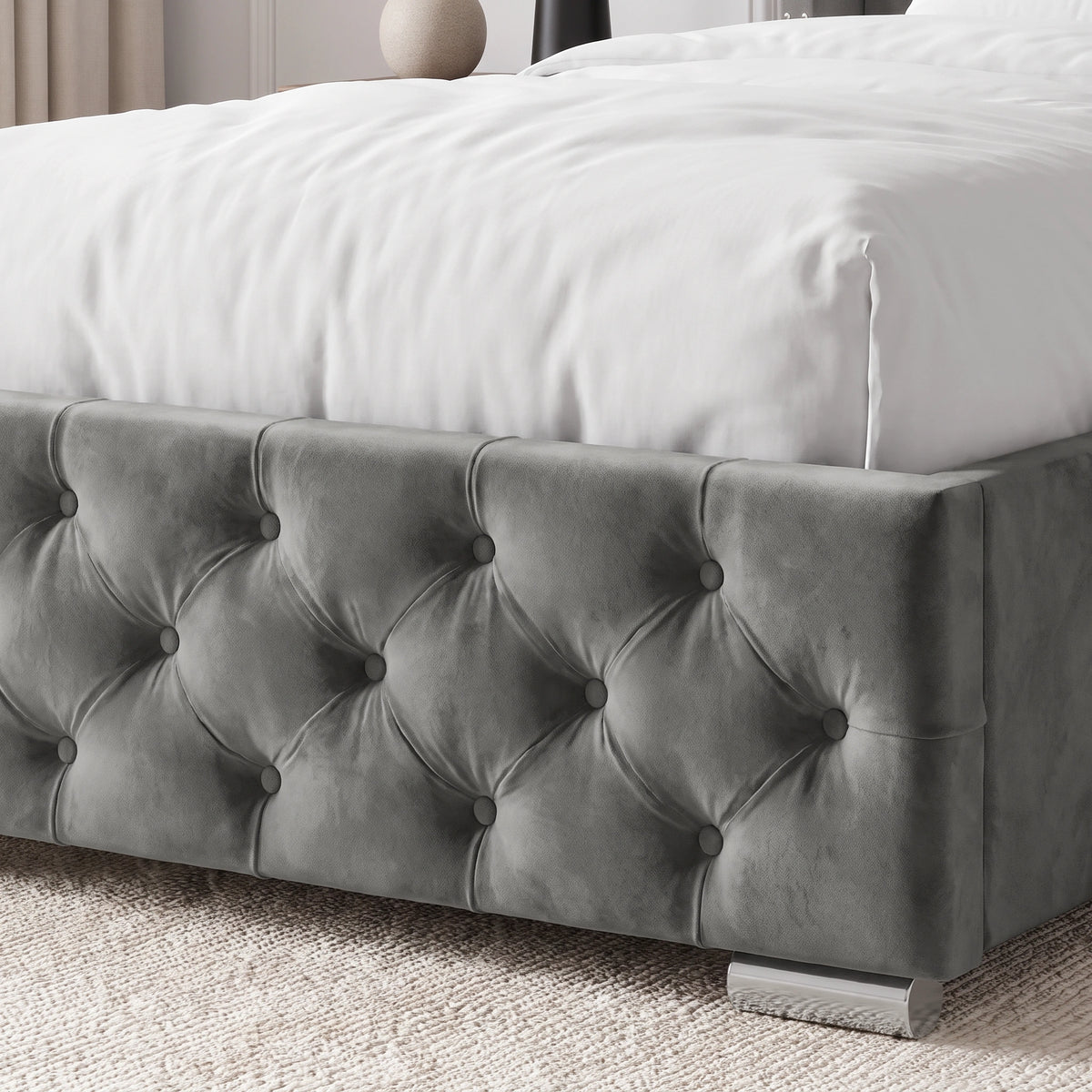 [Single | Grey] A gray tufted velvet bed frame with a white bedspread, shown in a softly lit bedroom setting with a textured rug and neutral decor.