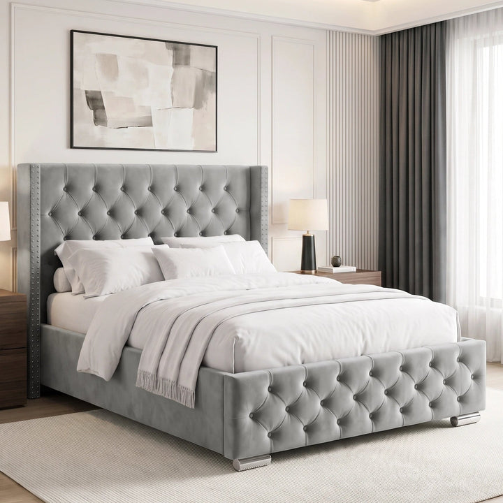 [Double | Light Grey] tufted velvet bed frame with a high wingback headboard and matching footboard, styled in a bright, contemporary bedroom with white bedding, wooden nightstands, and a large window.