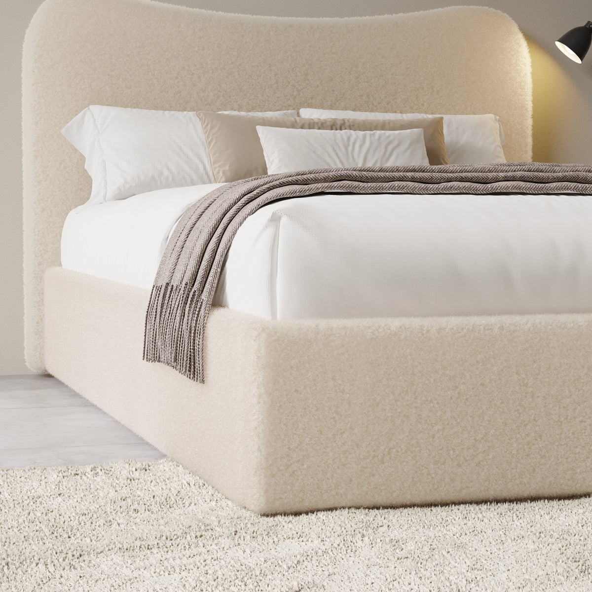 [King | Beige] Three-quarter view of curved headboard and bedding showing boucle texture with fringed throw draped across