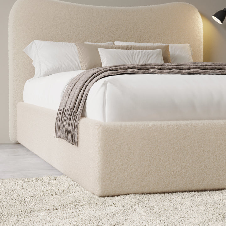[King | Beige] Three-quarter view of curved headboard and bedding showing boucle texture with fringed throw draped across