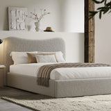 [King | Grey] Boucle fabric ottoman bed from the side with white bedding and fringed throw beside floating shelf with art