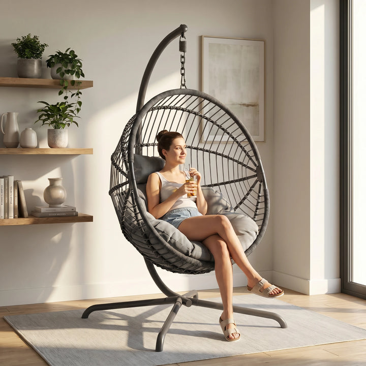 [Dark Grey] Woman sitting in a hanging egg chair in a bright room with plants and shelves