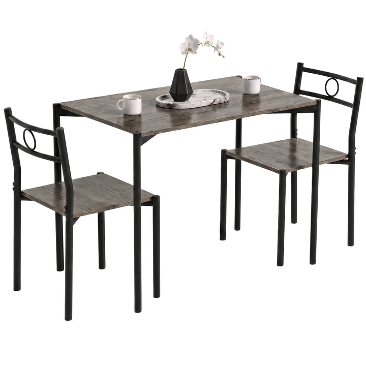 [Dark Wood] Angled studio view of the three-piece dining set with two chairs, black round-pipe frames, mugs and a vase on a tray