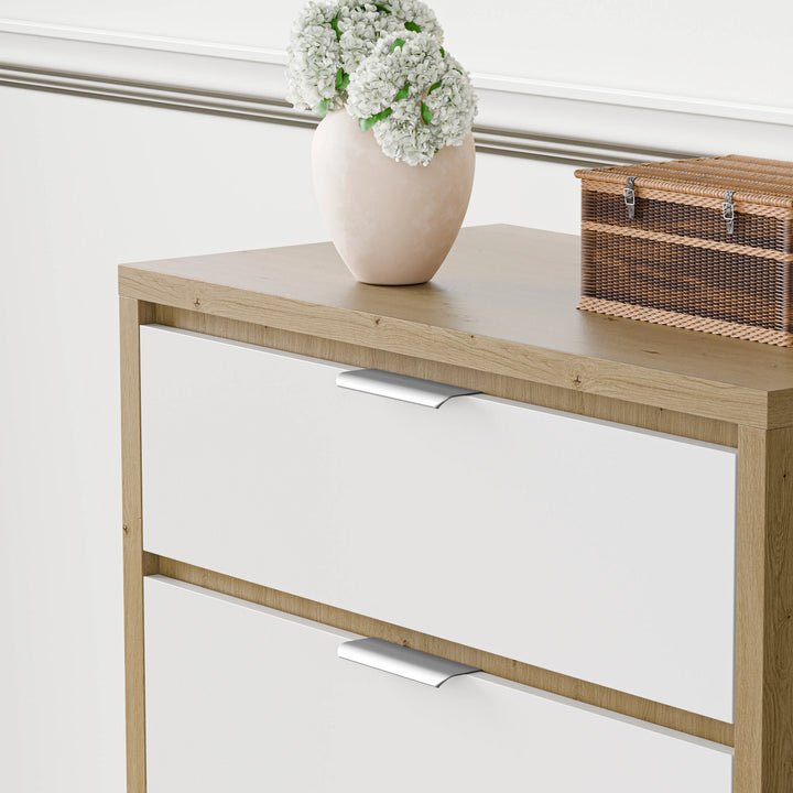[Oak+White] close-up of Skova 4 drawer chest of drawers showing oak top with a white vase and woven box