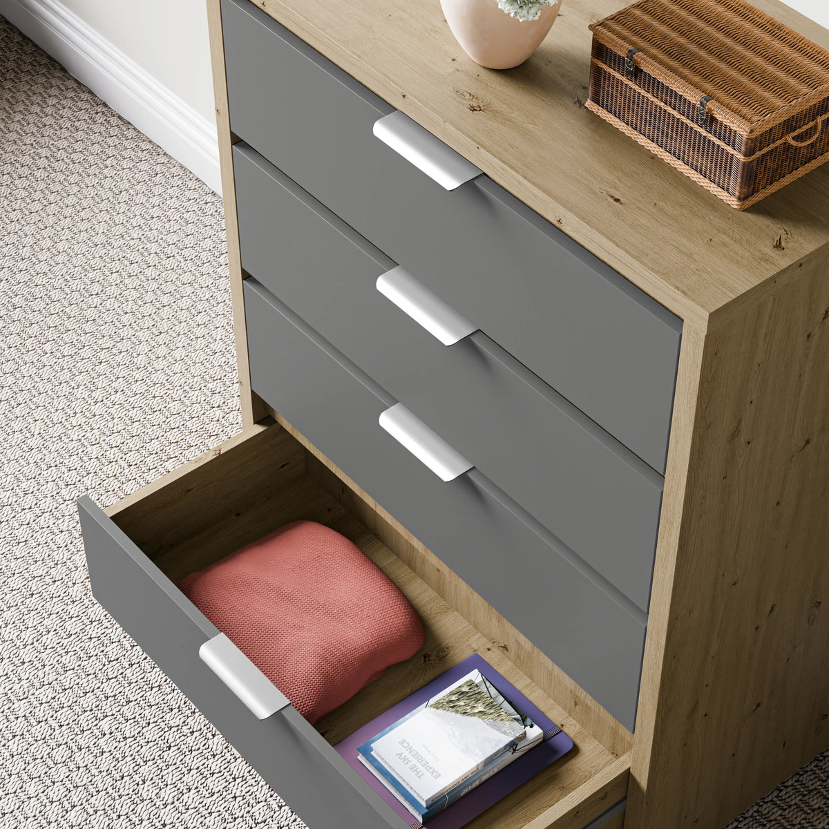 [Oak+Grey] finish deep chest of drawers with a lower drawer open, showing folded cloth and books placed against a wall