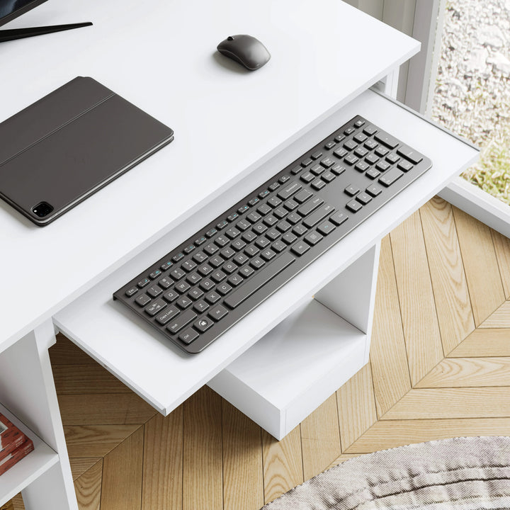 [White] Close-up of pull-out keyboard tray on small computer desk in white with black keyboard and mouse