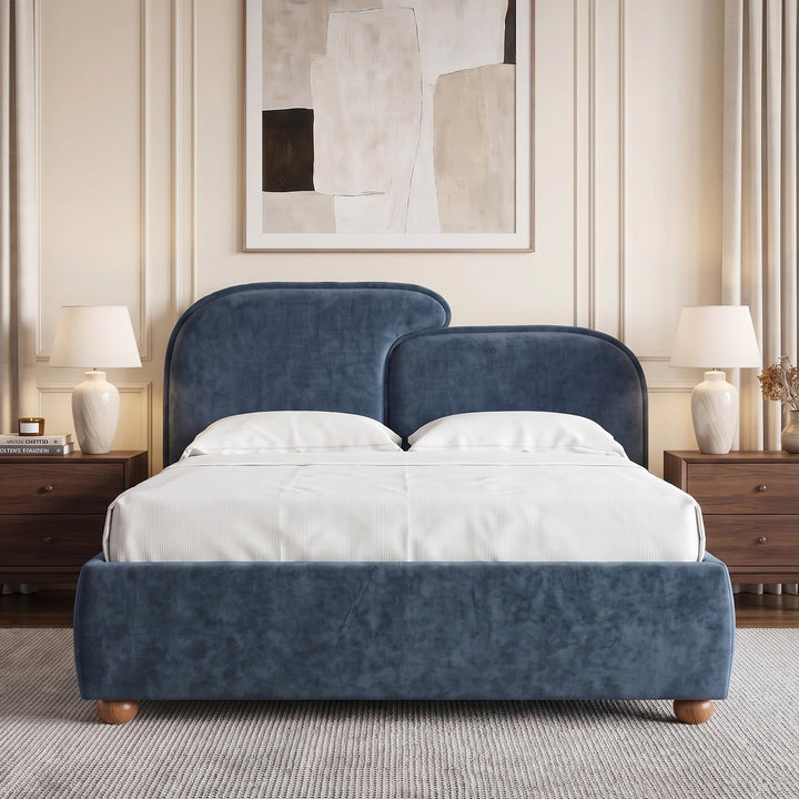 [Double | Blue] upholstered bed with a dual rounded headboard and matching footboard, dressed in white and beige bedding, set against a wood-paneled wall