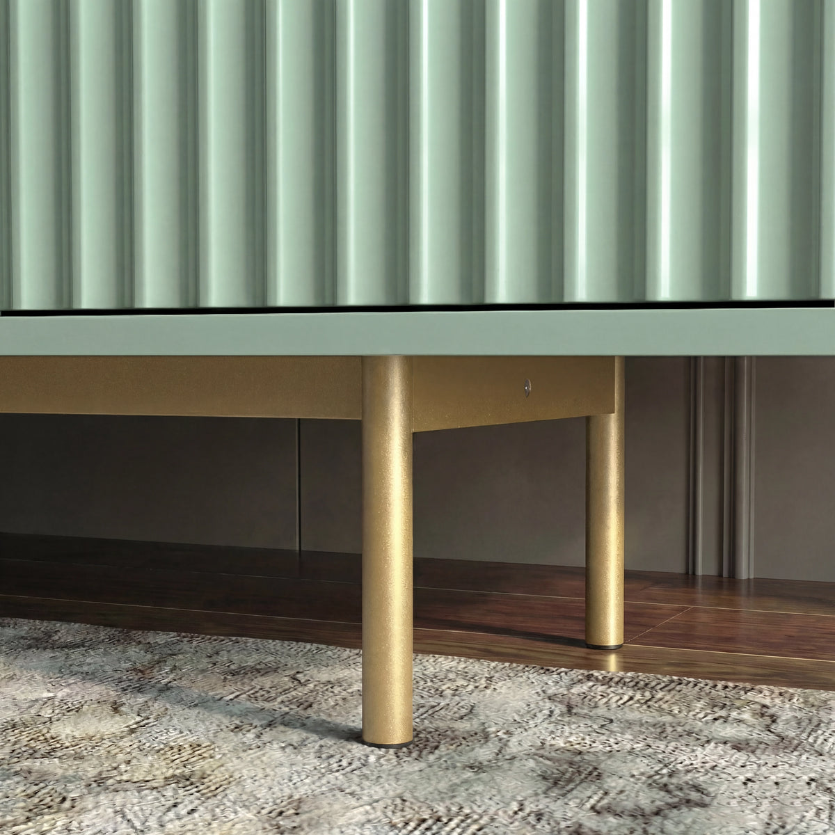 [Sage Green] Leg detail of sage green TV unit, brass cylindrical legs visible against wood floor and patterned rug.