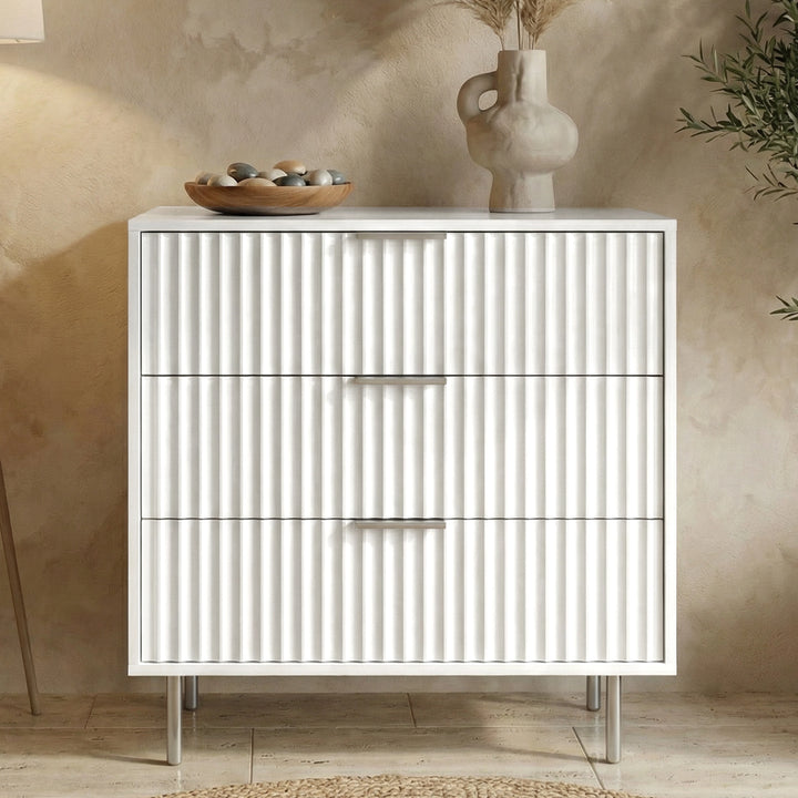 [White] Flutrina 3 drawer chest with vertical ribbed fronts, stone bowl and tall vase resting on top
